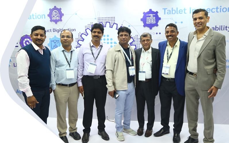 Company team members standing together at a technology expo, posing for a group photo in front of an exhibition booth.