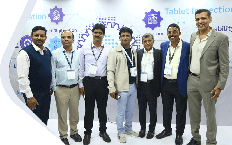 Company team members standing together at a technology expo, posing for a group photo in front of an exhibition booth.